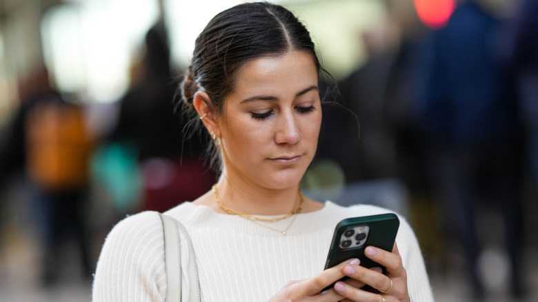 Woman looks skeptically at phone