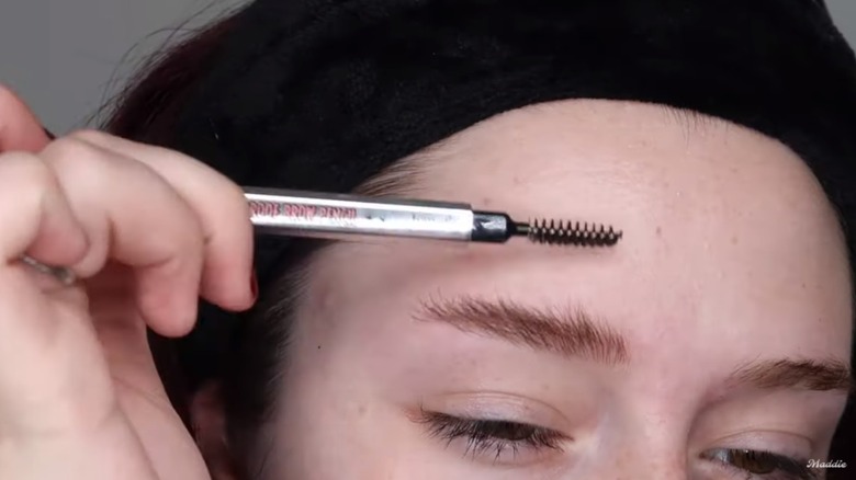 Madison Ashleigh brushing eyebrow with spoolie