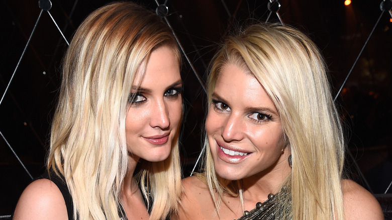 Ashlee and Jessica Simpson posing at event