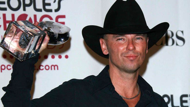 Kenny Chesney  at an award ceremony with his award