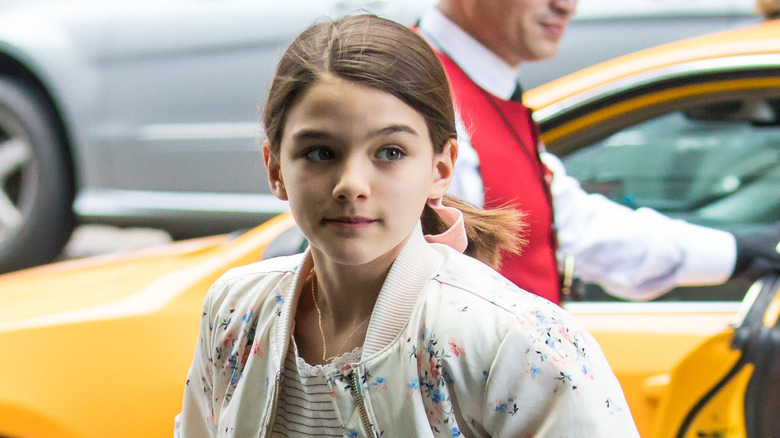 Suri Cruise running out of a yellow cab as a child