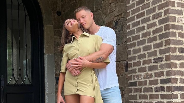 Olivia Culpo is hugged by Christian McCaffrey