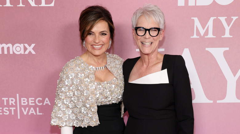 Mariska Hargitay wering a black and white gown with floral detailing smiling next to a beaming Jamie Lee Curtis in a black gown with a pop of white on top