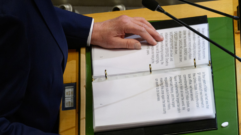 Hand on a binder containing a typed speech
