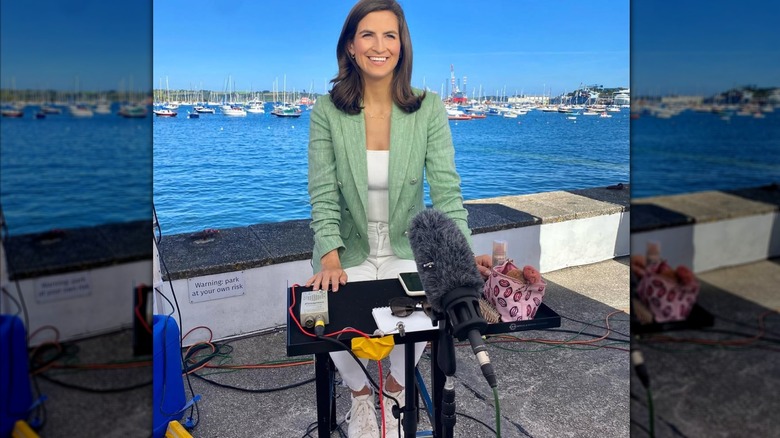 Kaitlan Collins sitting in front a microphone and smiling