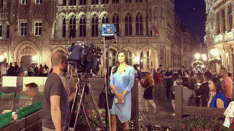 Kaitlan Collins standing in front of a camera