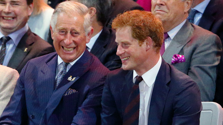 Prince Charles and Prince Harry sitting together laughing 2014