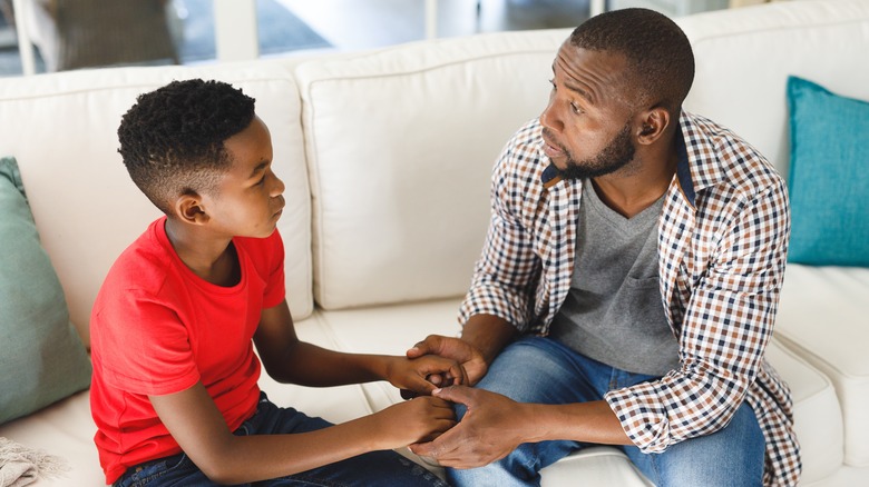 Black father and son having serious conversation