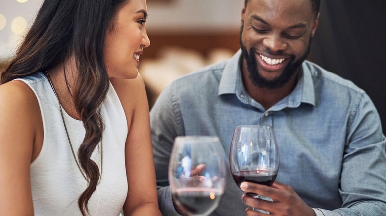 Woman and man smiling with glasses of wine