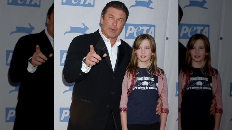 Alec Baldwin pointing with his other arm around Ireland Baldwin.