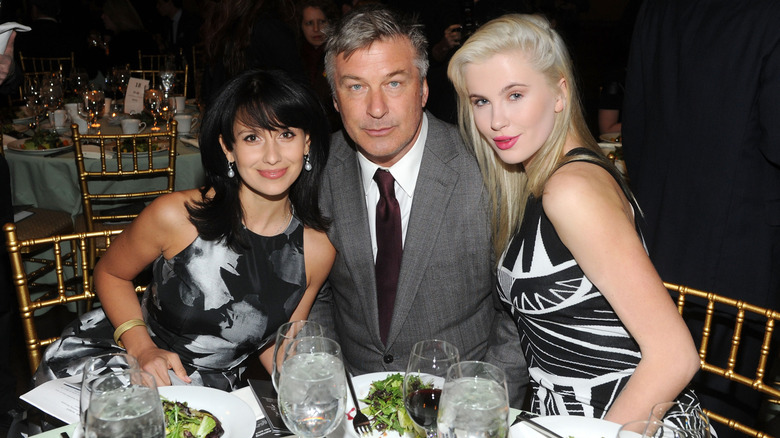Hilaria, Alec, and Ireland Baldwin posing at a dinner table.