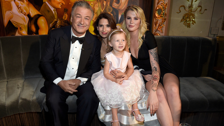 Hilaria Baldwin sitting between Ireland Baldwin and Alec Baldwin with her daughter Carmen in her lap.