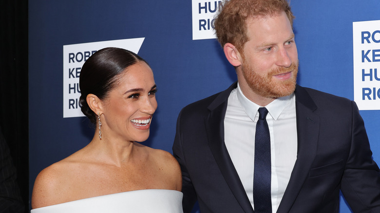 Harry and Meghan at event smiling 