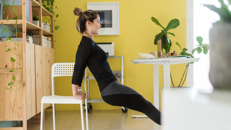 Woman doing chair dips at desk