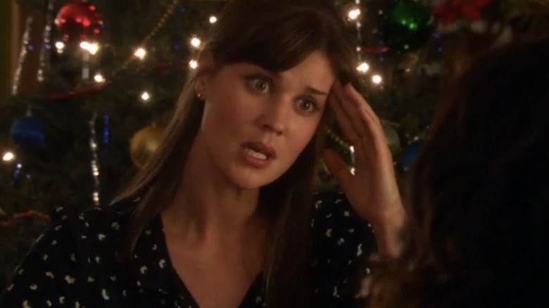Sarah Lancaster as Elise looking stressed in front of a Christmas tree in Fir Crazy (2013)