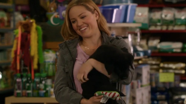 Erika Christensen as Bailey Daley holding a small black dog in My Boyfriends' Dogs (2014)