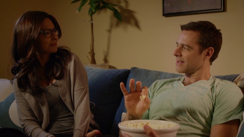 Vanessa Marcil and David Sutcliffe talking on a couch in a scene from "The Convenient Groom" (2016)