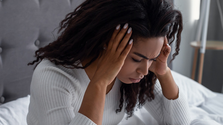 woman in bed with headache from hangover