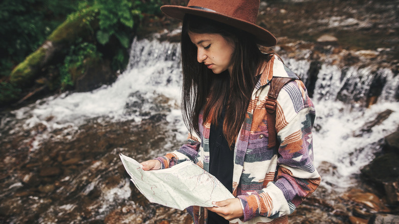 Hipster woman hiking with map
