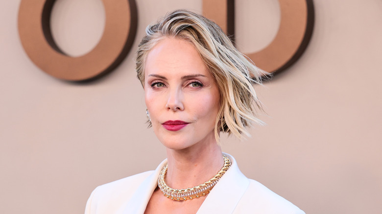 Charlize Theron in a white blazer with golden jewelry