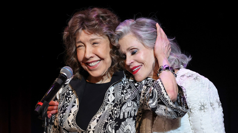 Jane Fonda with her head on Lily Tomlin's shoulder