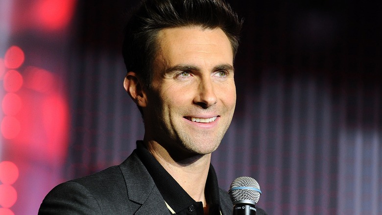Adam Levine holding a microphone