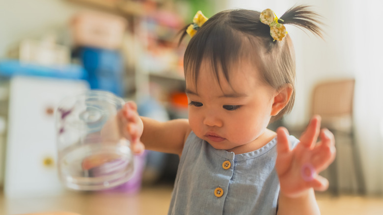 Toddler holding a jar
