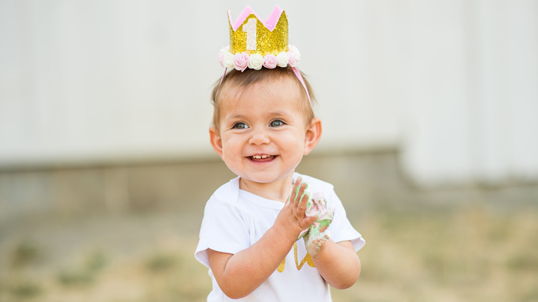 Baby wearing crown and clapping