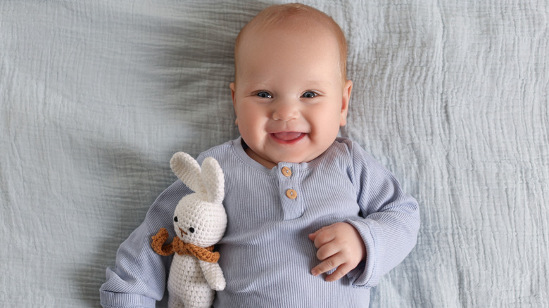 Baby laughing with stuffed bunny