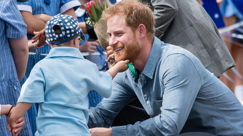 Prince Harry, Duke of Sussex is greeted by 5-year-old Luke Vincent as they arrive at Dubbo Airport on October 17, 2018 in Dubbo, Australia (2018)