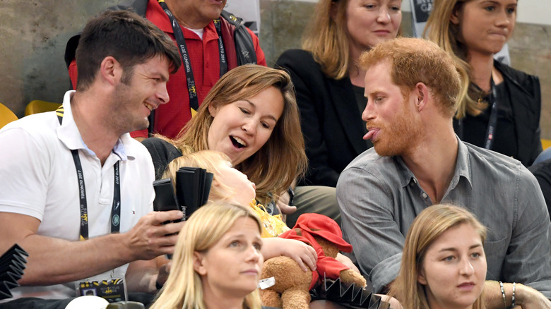 Prince Harry attends the Sitting Volleyball on day 5 of the Invictus Games Toronto 2017 and sticks his tongue out at the child sitting next to him (2017)