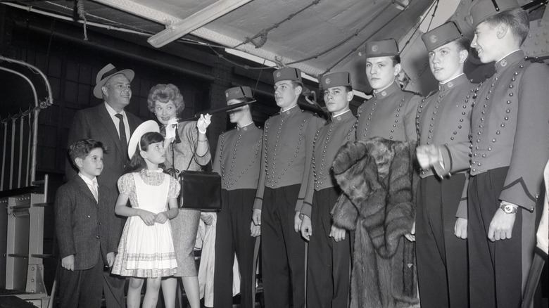 Lucille Ball And Her Husband Desi Arnaz And Their Two Children, Lucie, And Desi Jr. Ball Is Shown Here Aiming Her Umbrella At A Row Of Bellhops Aboard The Liberte