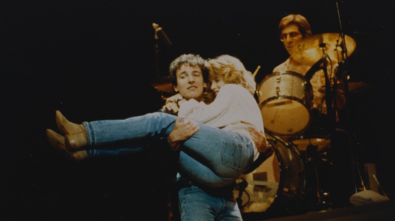 Bruce Springsteen carrying his then-wife Julianne Phillips on stage
