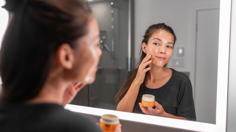 woman putting on face mask