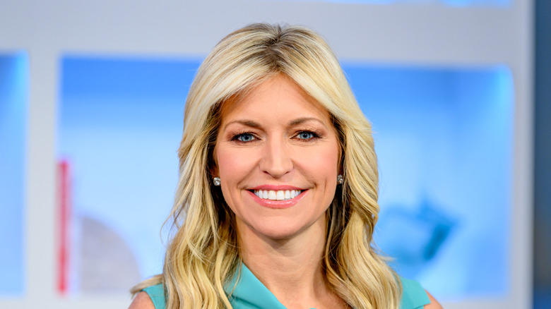 Ainsley Earhardt smiling at the studio wearing a light green dress.