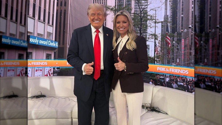 Ainsley Earhart posing with Donald Trump, both flashing a thumbs up