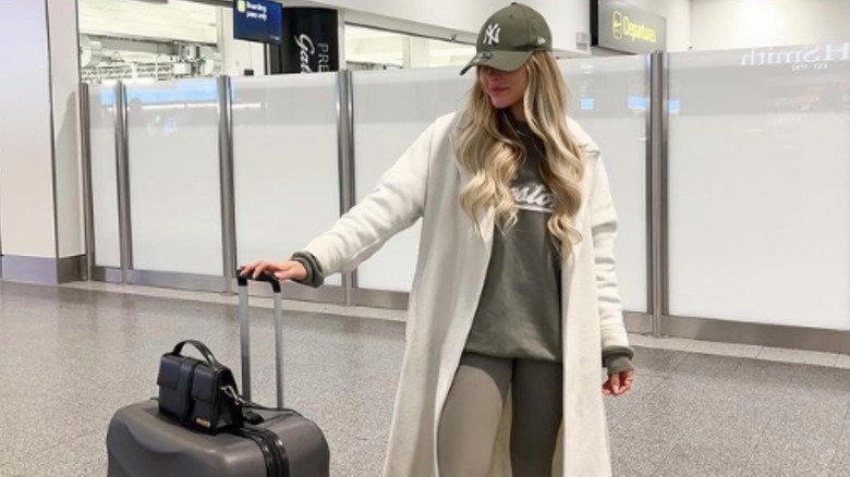 woman holding luggage posing in airport