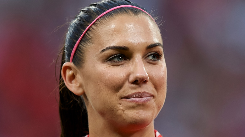 Alex Morgan smiling on the field. 