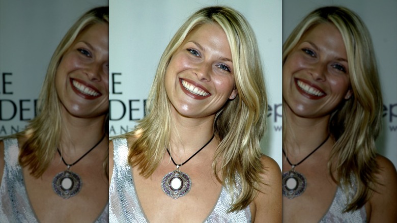 Ali Larter wears a statement necklace featuring a black cord and large jeweled medallion.