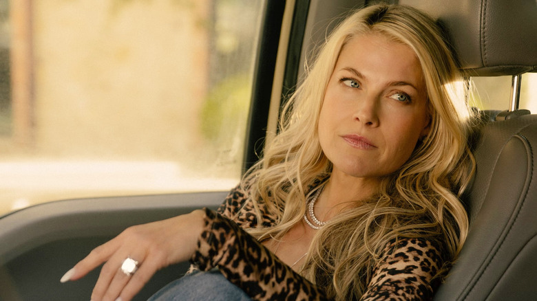 Ali Larter sitting in the front seat of a car in a scene from Landman