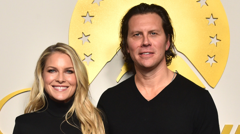 Ali Larter and her husband Hayes MacArthur posing while embracing in matching black outfits