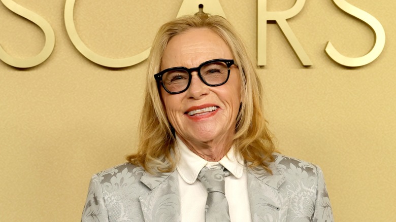 Amy Madigan in a silver paisley suit on the red carpet of the Oscars Nominee Luncheon