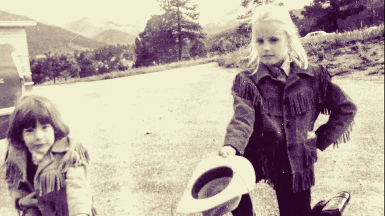 Daryl Hannan in fringed jacket holding cowboy hat with her sister