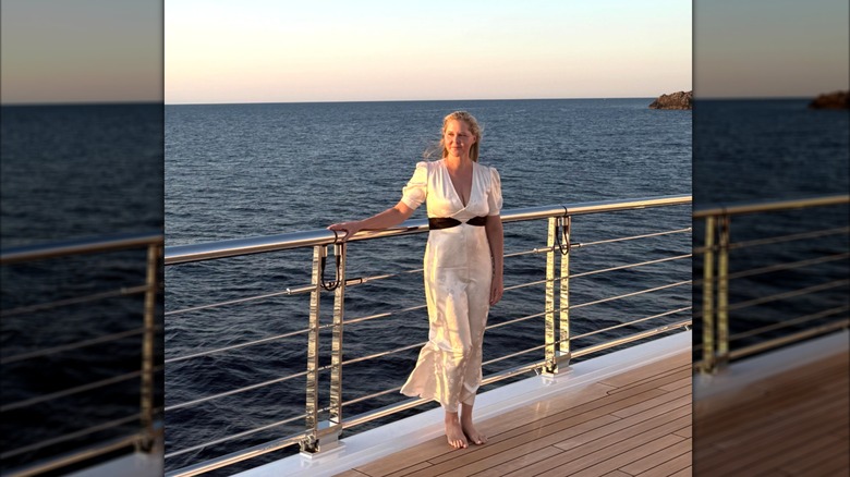 Amy Schumer in a white dress with a black belt on a yacht
