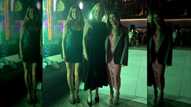 Amy Schumer in a black dress with two friends outside