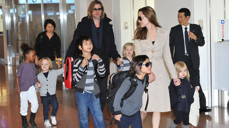 Brad Pitt, Angelina Jolie, and their six kids walking through an airport
