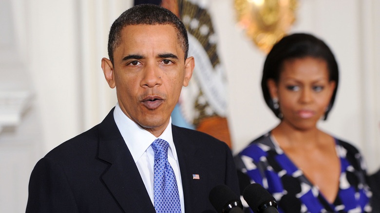 Barack Obama making a speech with Michelle behind him, 2010