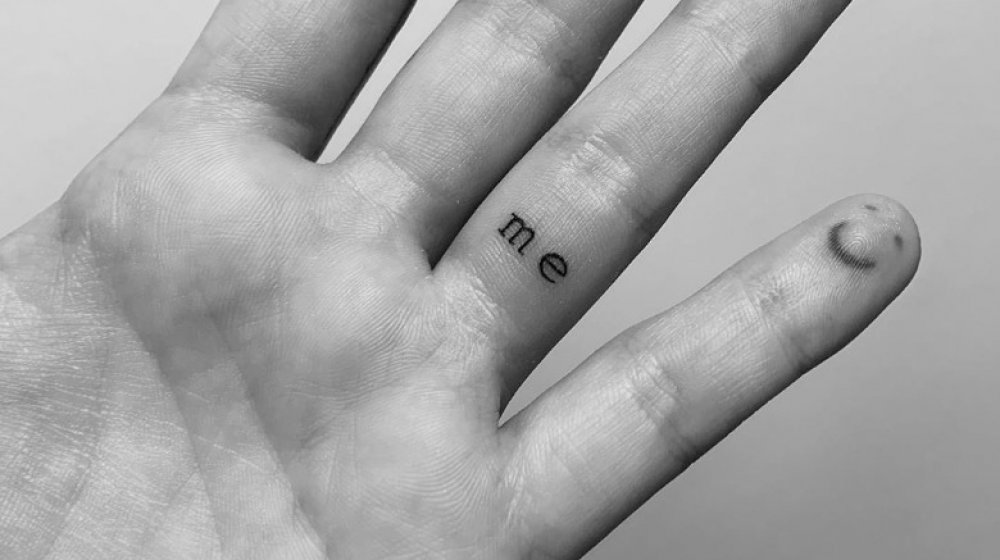 Mão de Demi Lovato com tatuagens