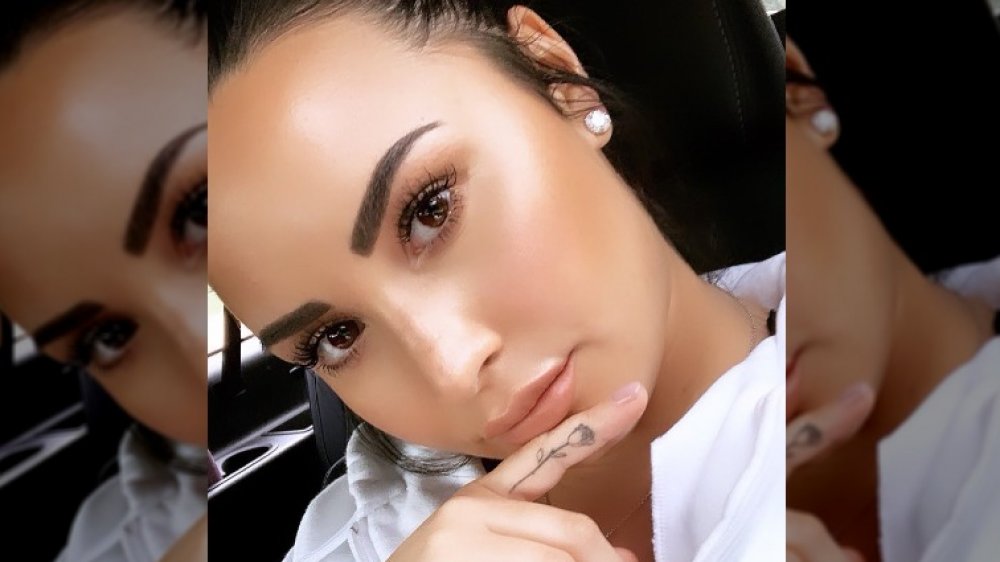 Demi Lovato close-up showing off her rose finger tattoo