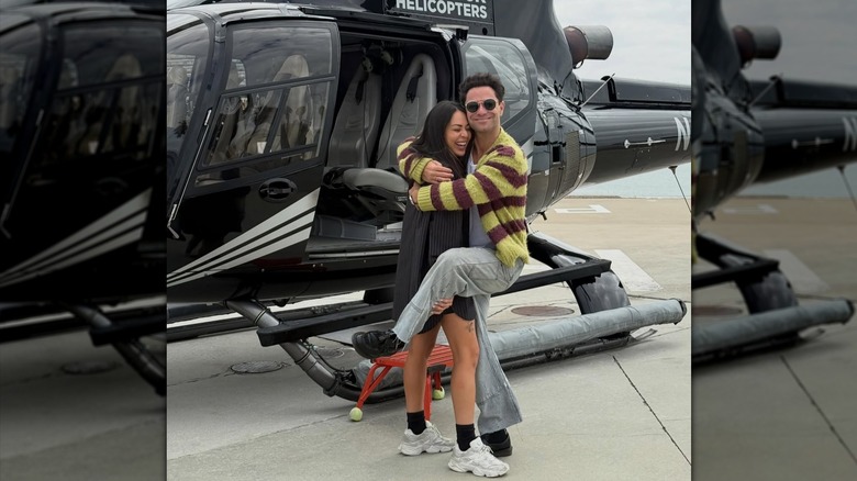 Sasha Farber hugging Janel Parrish in front of a helicopter.